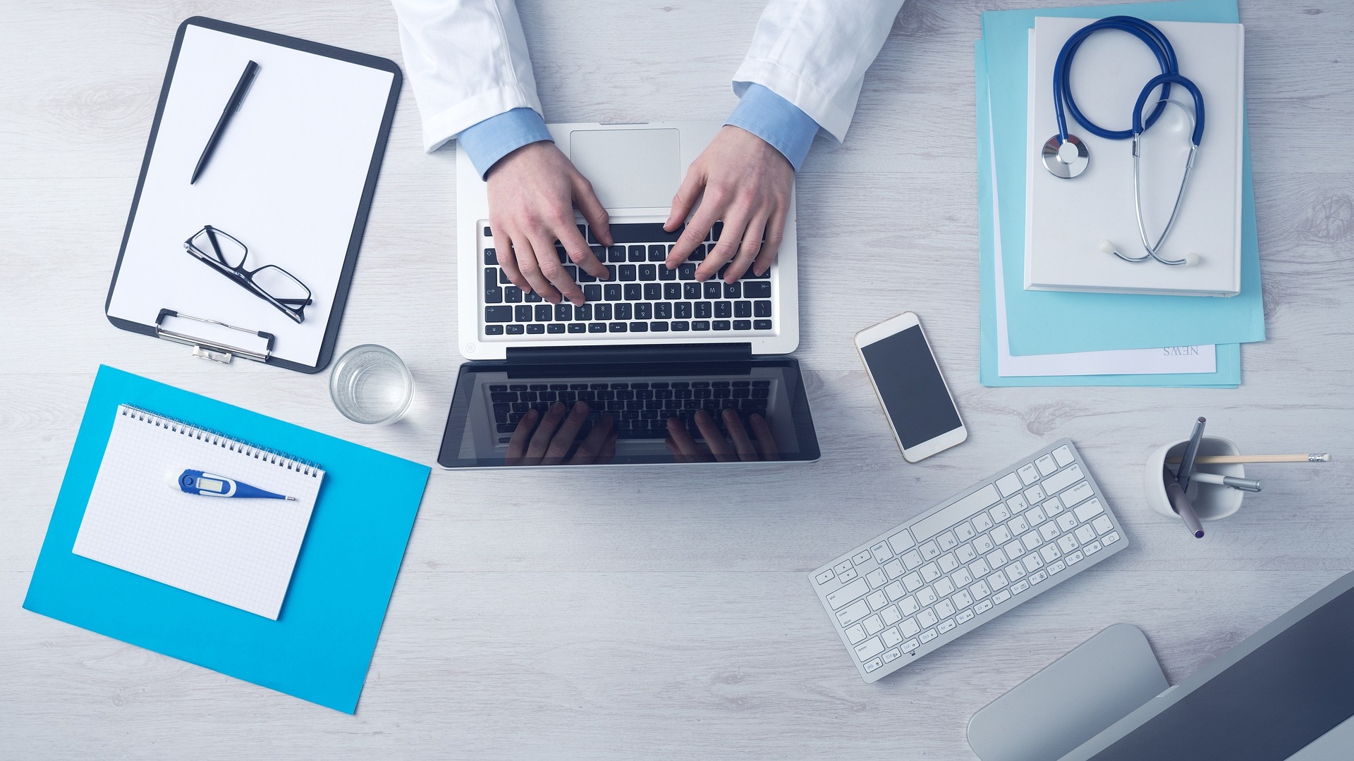 Bureau médical organisé avec ordinateur, stéthoscope et documents administratifs