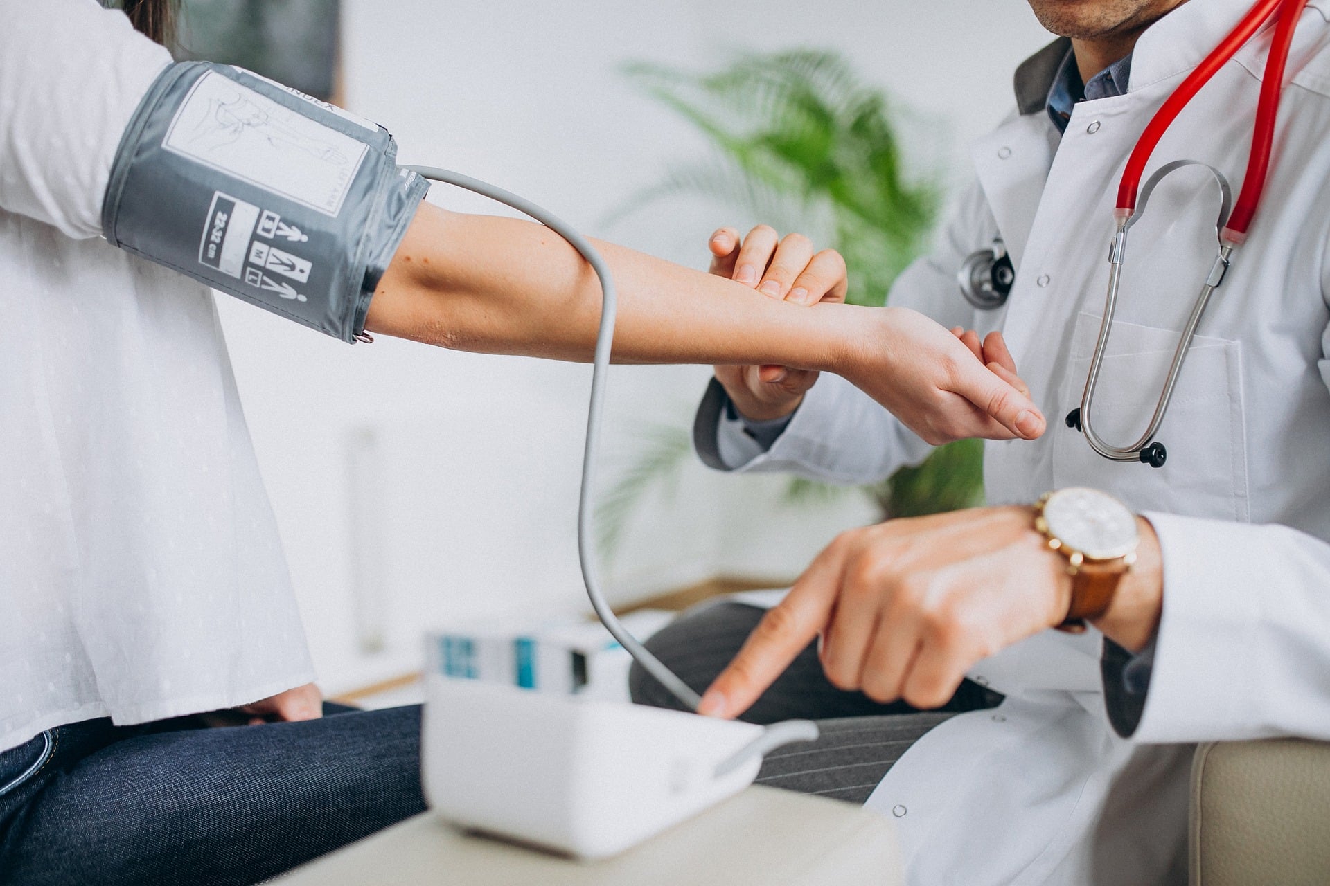 Médecin prenant la tension artérielle d'un patient lors d'un suivi clinique